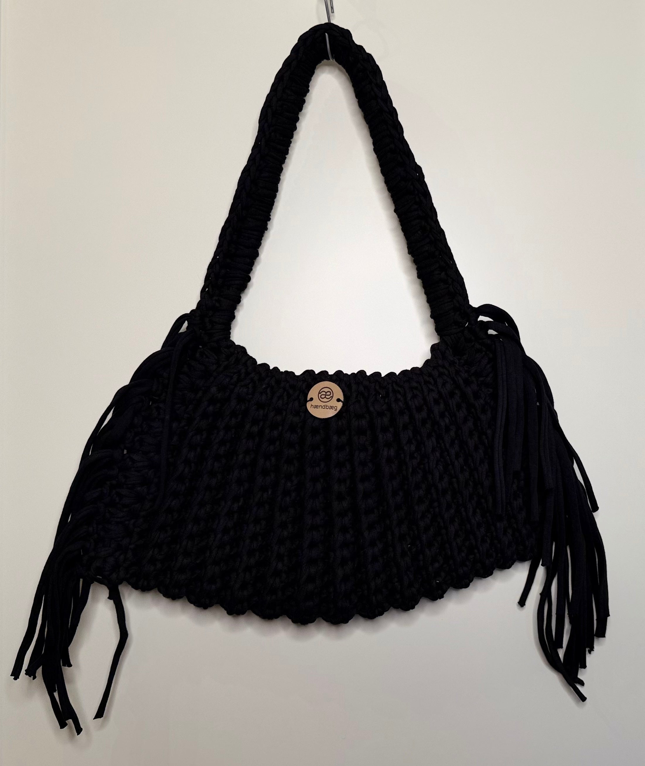 Håndlaget svart veske med frynser
