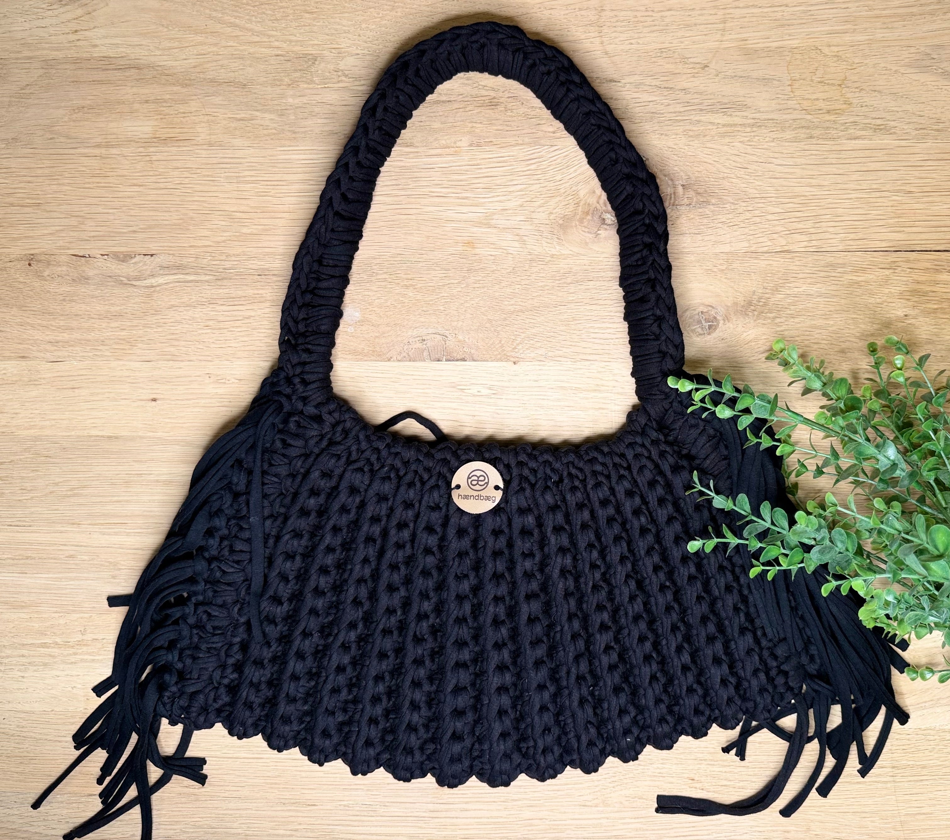 Håndlaget svart veske med frynser