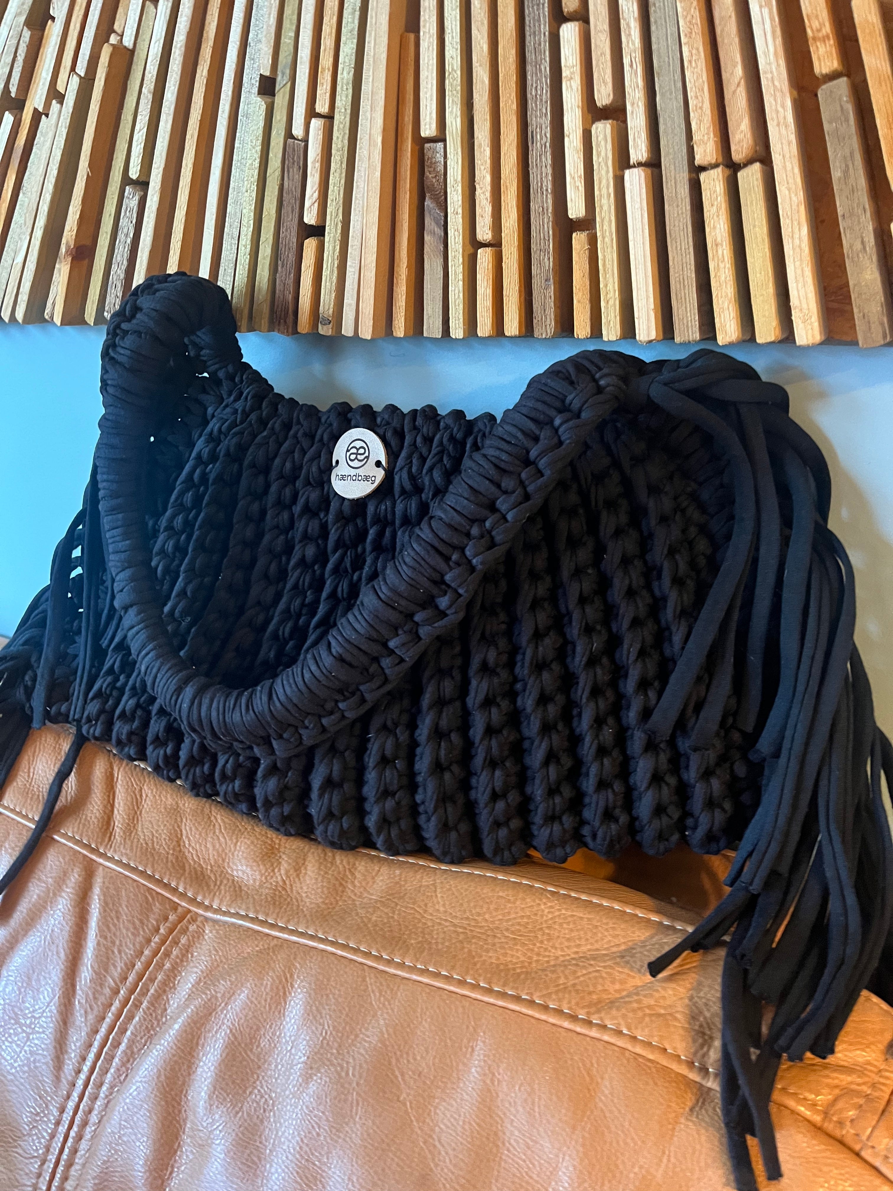 Håndlaget svart veske med frynser